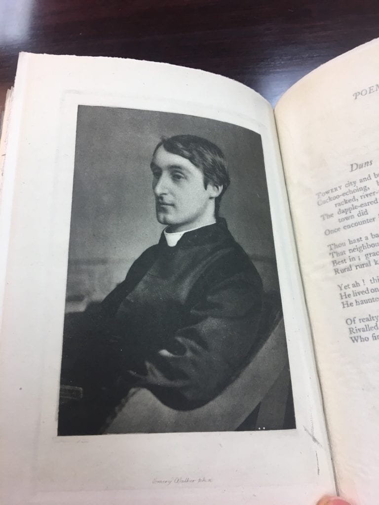 Image from a book of Gerard Manley Hopkins in profile and sitting in a chair. He has dark hair and is wearing a white priest's collar..