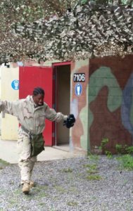 Cadet Hagood walks out of the gas chamber after breathing in CS gas. She was instructed to immediately start fanning her arms up and down and continually spit out any chemical residue breathed in. 