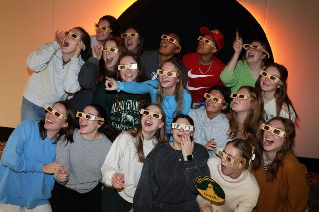 students posing in eclipse safety glasses