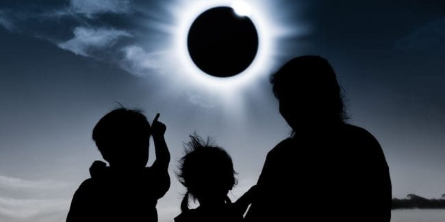 Adult and two children viewing eclipse